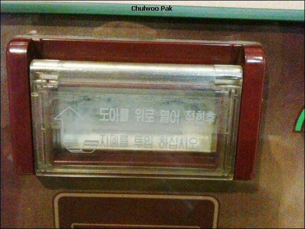 도아를 위로 열어 젖힌후 지폐를 투입 하십시오.